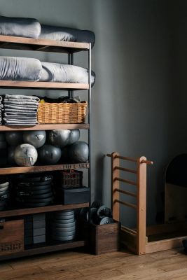 Neat arrangement of gym equipment and yoga mats in a modern fitness studio.